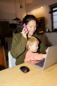 Mother multitasking working from home with child