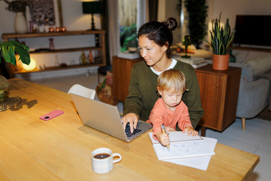 Mother and child working from home balancing tasks