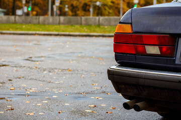 Details of a classic blue car in the rain — close-up of the body with water droplets, chrome...