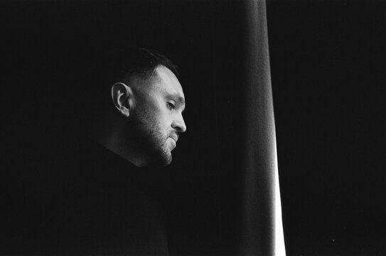 Man looking out of window in dramatic light