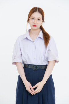 tudio portrait of asian cheerful happy young teenage girl woman wearing eyeglasses white blouse navy pleated skirt posing on white background, student high school uniform, education lifestyle concept