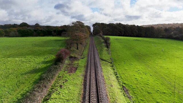 Epic bird&rsquo;s-eye drone view of a gleaming red steam train chugging through the countryside as thick white smoke billows skyward, filling the frame with cinematic atmosphere and motion.