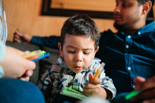 Toddler Concentrating on Coloring Notebook