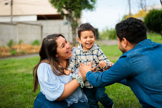Parents Playing and Laughing with Their Son Outdoors