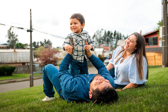 Latin Parents Playing with Son on the Grass