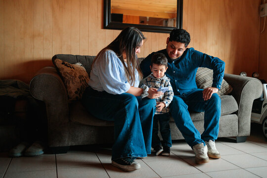 Parents Helping Toddler with Smartphone at Home