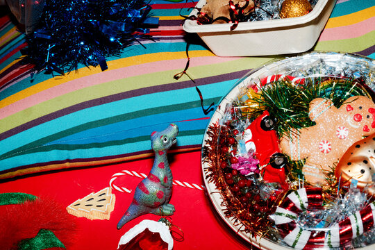 a dinosaur toy beside candy canes and christmas stuff