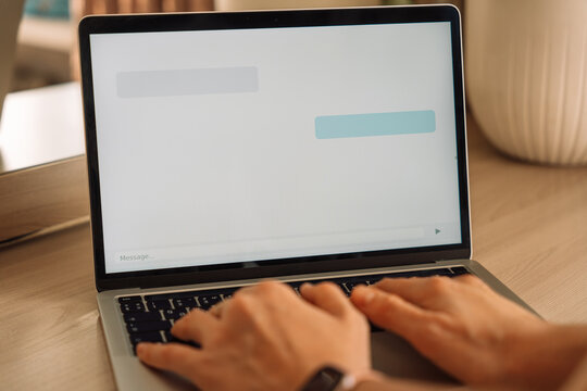 Typing a message in AI chatbot on laptop screen. High quality photo