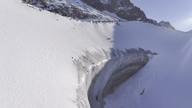Alpinists ice climbing a huge glacier crevasse in the high mountains, Bogdanovich glacier