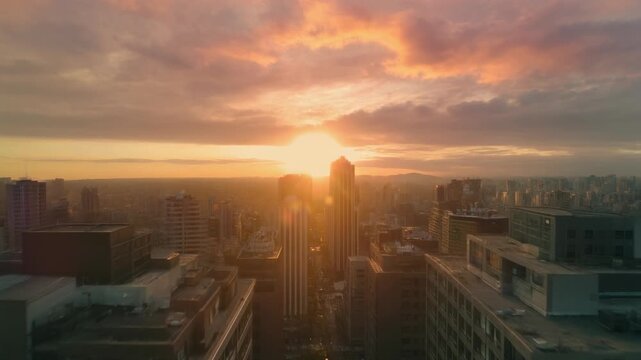 Panoramic urban cityscape at dawn or dusk, bathed in the vibrant, golden hues of a breathtaking sunrise or sunset, creating a serene and majestic aerial vista