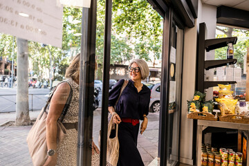 Two senior women entering store for shopping