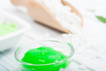 beauty product samples with chamomile flowers on white wooden table