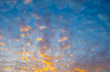 Golden sunrise clouds glowing in dramatic blue sky panorama