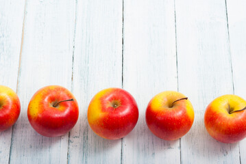 apple fruits in a row, white wooden table background