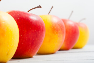 apple fruits in a row, white wooden table background