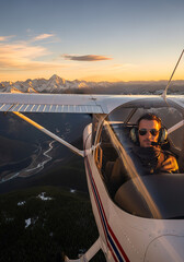 A pilot flying a small aircraft over scenic landscapes.