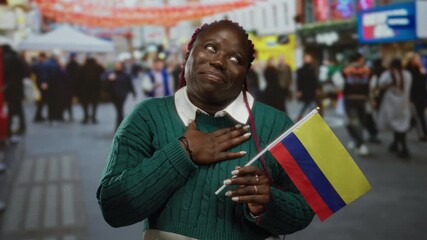 Woman holding colombian flag on vibrant city street, expressing joy and pride, with diverse crowd in background, representing multicultural celebration outdoor. - Powered by Adobe