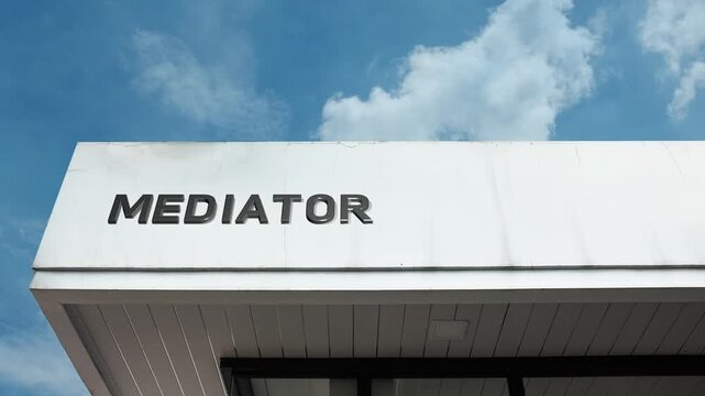 A mediator word sign prominently displayed on a professional building under a clear blue sky, symbolizing impartial conflict resolution and guidance