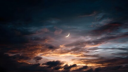 Naklejka premium A striking crescent moon illuminates a dramatic textured sky filled with dark warm toned clouds at dusk