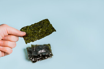 Dried nori leaf, healthy seaweed chips on a blue background