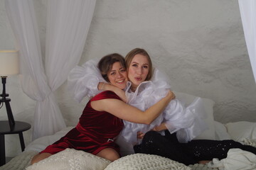 two friends are sitting in the bedroom in the evening, talking, supporting each other,