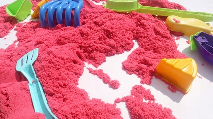 Bright pink Kinetic Sand Play with Colorful Play Toys for Sensory Fun.
