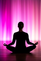 Silhouette of woman practicing yoga in lotus pose, meditating with purple light background