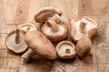 Raw shiitake mushrooms on wooden table, top view.