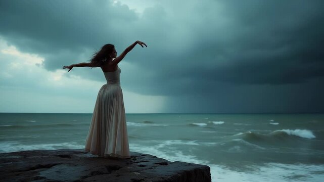 Young woman im white dress standing on the edge of the cliff in the ocean, big wave rising and falling on that cliff, ramatic sky, concept of freedom