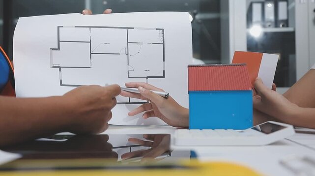 team of multiethnic architects working on construction plans in meeting room engineers discussing on project in office mature businessman and woman standing around table working on blueprint no logos