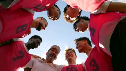 Soccer team and coach huddling together before a game