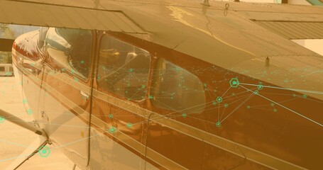 Showing red-white prop plane fuselage with wing strut, cockpit window, network node overlay on ramp