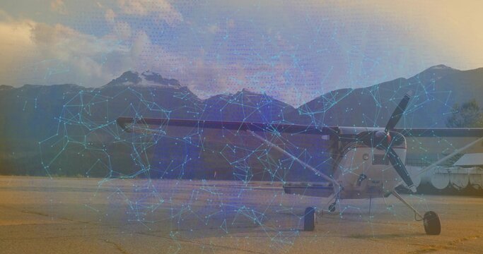 Single-engine propeller airplane displaying digital overlay on tarmac by water, with blue network