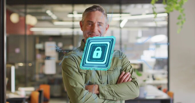 Mature man in green shirt folding arms in open-plan office, with monitors and padlock overlay - Powered by Adobe