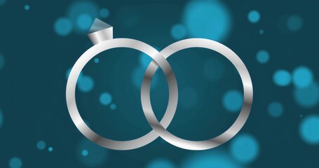 Glimmering diamond topped ring interlocking with plain silver band on teal background, bokeh lights