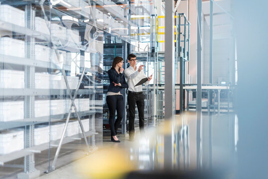 Employee meeting with tablet in modern production hall