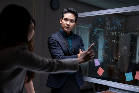 Business colleagues collaborating on strategy plan in dark office