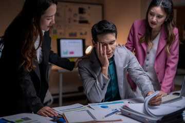 Colleagues supporting stressed man working overtime at office