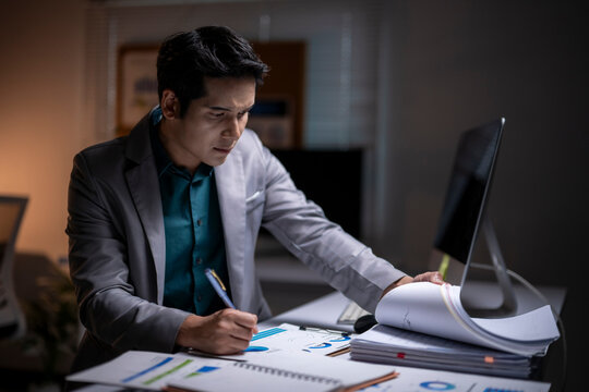 Businessman working late analyzing financial data in office