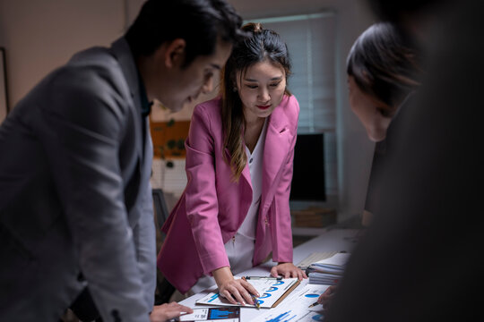 Business colleagues collaborating on data analysis during late night meeting
