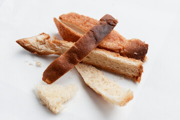 Sad and disappointing pile of overcooked burnt bread crust. food waste and leftover cooking mistake isolated on white background show culinary failure