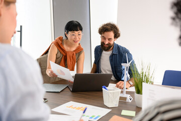 Team collaborating at office desk analyzing charts and planning project