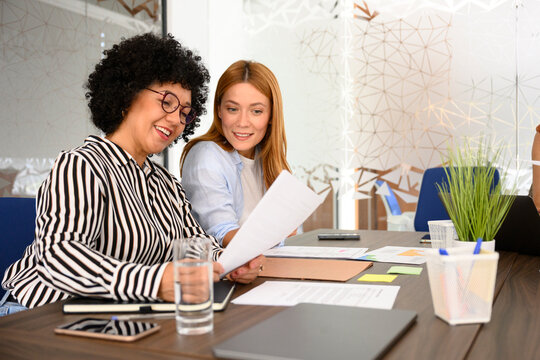 Colleagues working together reviewing charts in modern office