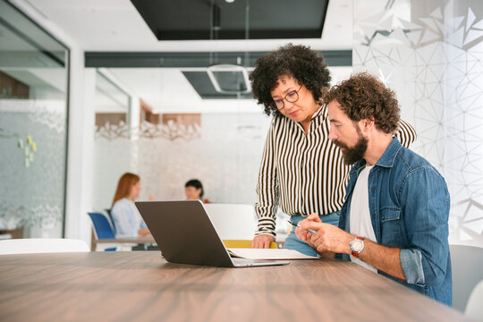 Colleagues collaborating and working together with a laptop in office