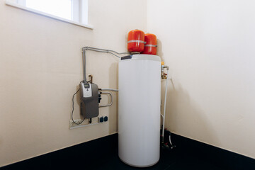 Obraz premium thermal tank installation, energyefficient utility tank situated beneath window with accessible