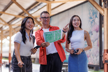 Diverse group of friends traveling exploring map at station