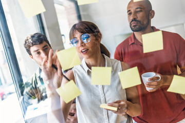 Team brainstorming and collaborating with sticky notes in a modern office
