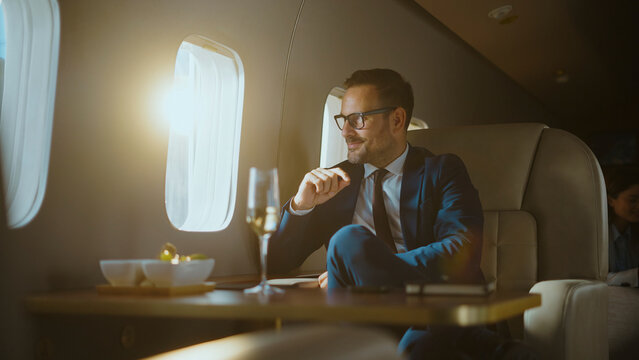 Successful businessman traveling in a private plane, sitting by the window with a glass of champagne, symbolizing first-class travel, corporate success, and the comforts of executive transportation