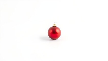 A single red ornament stands out against a pure white background, evoking holiday simplicity.
