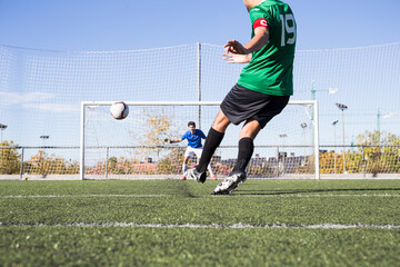 Football player shooting the ball on football field